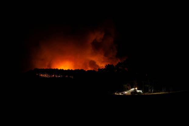 A tractor cleans up land during a wildfire in Aljezur
