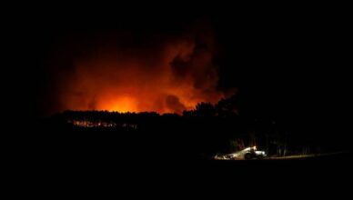 A tractor cleans up land during a wildfire in Aljezur