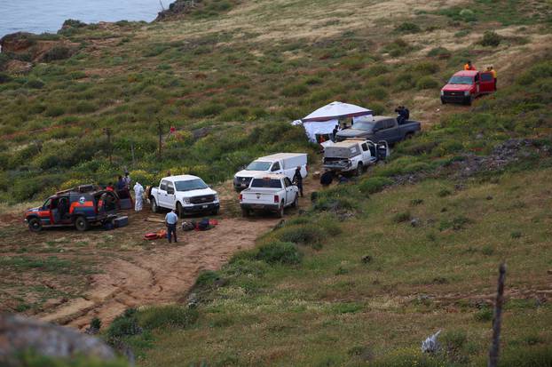 Members of a rescue team work at a site where three bodies were found, in La Bocana