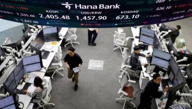 Currency dealers work in the dealing room of a bank, in Seoul