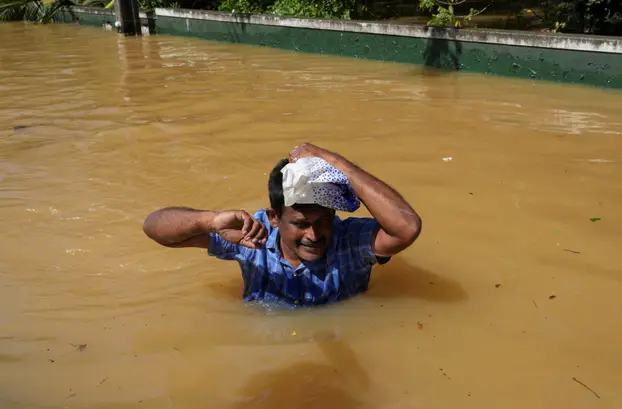 A man wades through a flooded street, following Cyclone Ditwah in Kelaniya