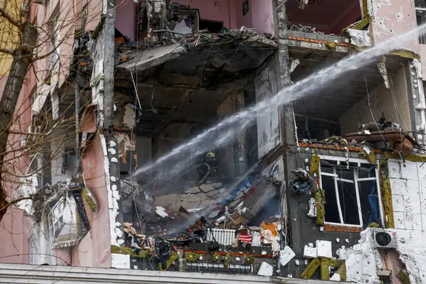 Firefighters work at the site of an apartment building hit during Russian missile and drone strikes, amid Russia’s attack on Ukraine in Kyiv